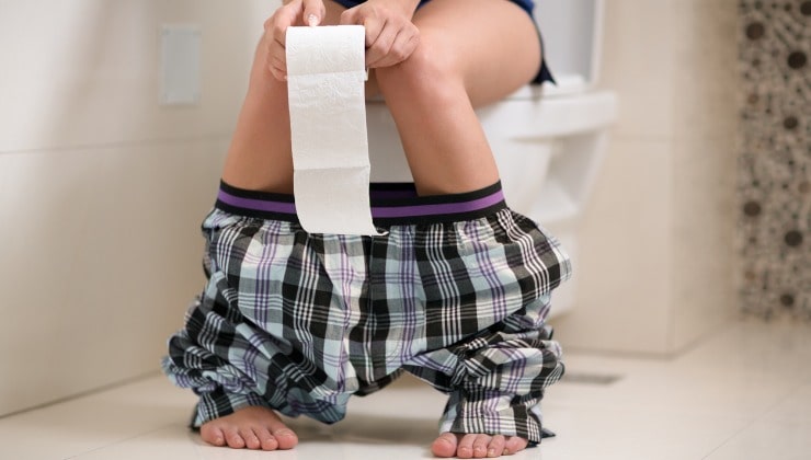 Joven sentado en el baño