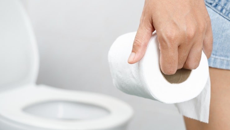 Mano con rollo de papel higiénico
