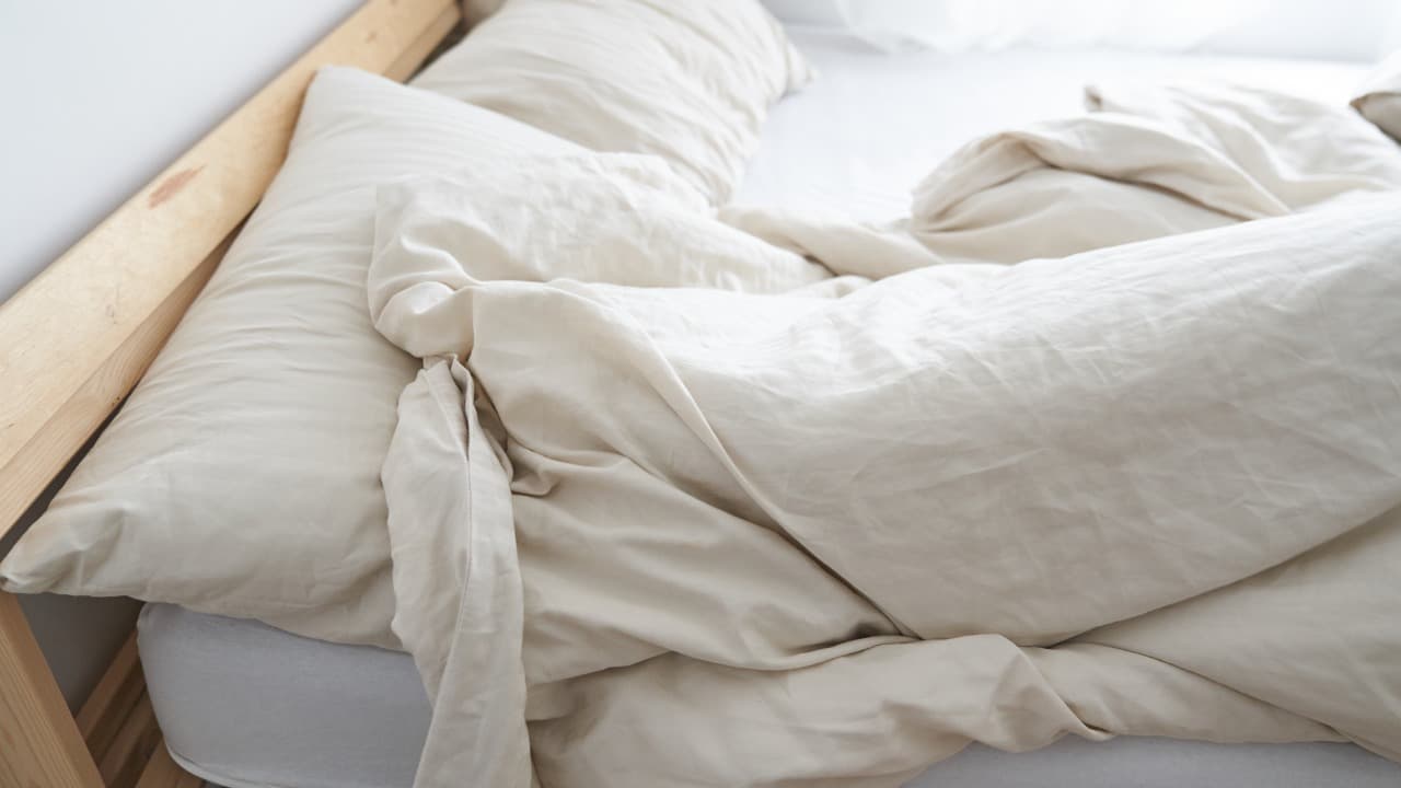 Cama deshecha, sábanas y bacterias.