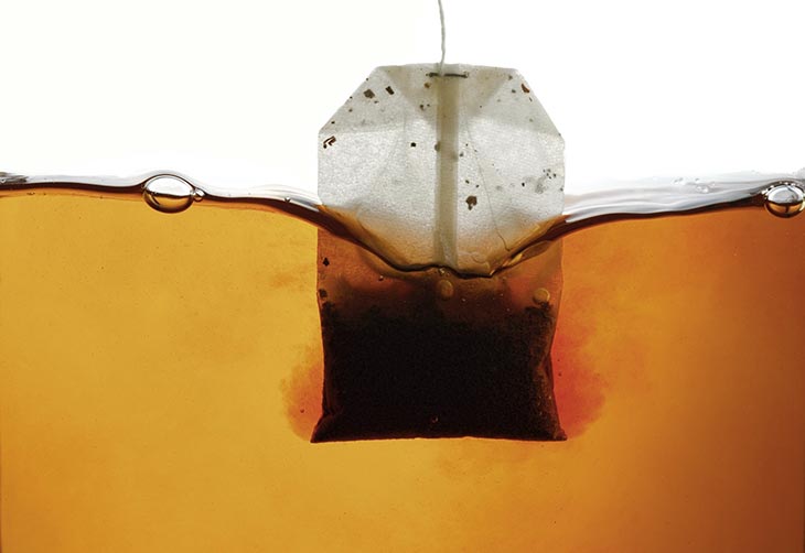 Bolsita de té negro empapada en agua caliente