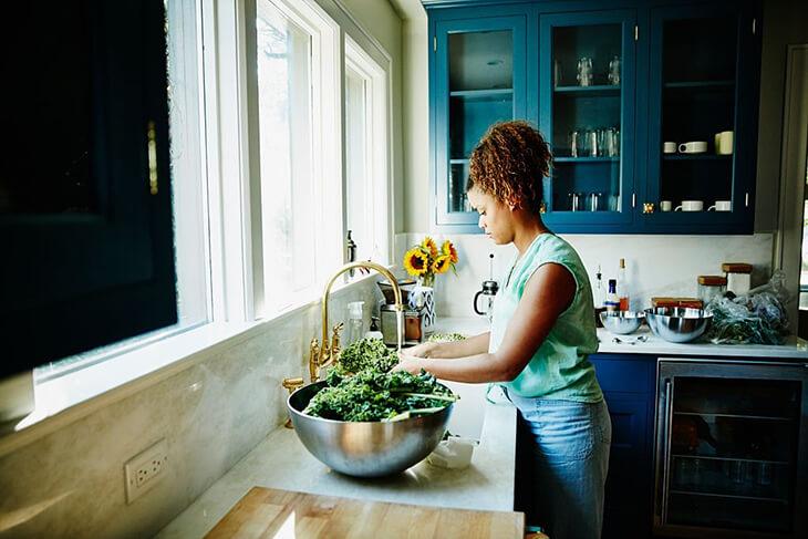 Un fregadero de cocina debajo de la ventana.